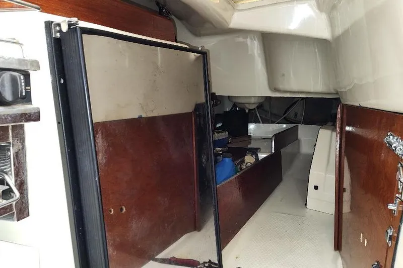 Slide: The Image of Interior of a 2002 Seaward Eagle 32 RK sailboat, featuring wooden paneling and storage compartments. - 29