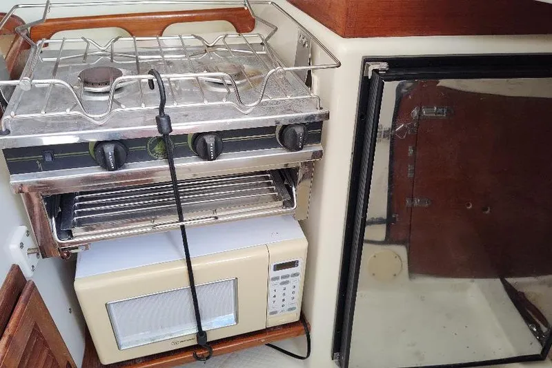 Slide: The Image of Compact kitchen area in a 2002 Seaward Eagle 32 RK boat with stove and microwave. - 30