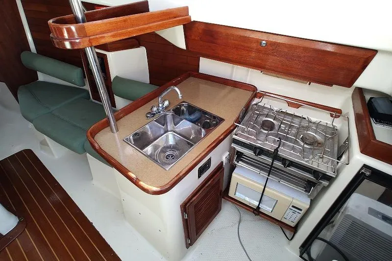 Slide: The Image of 2002 Seaward Eagle 32 RK yacht interior with kitchenette, sink, stove, and seating area. - 33