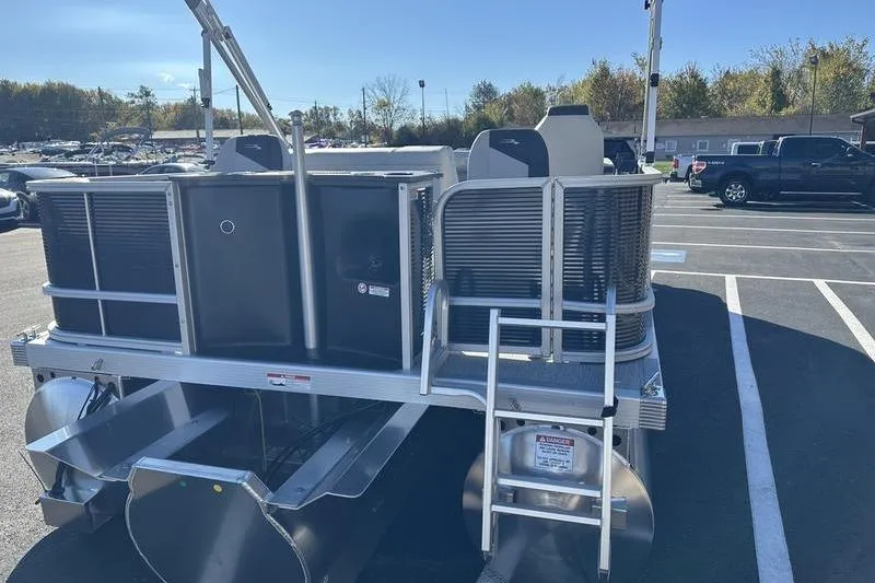Slide: The Image of 2025 Bennington S Fish 22 SF pontoon boat, rear view with ladder, parked outdoors. - 12