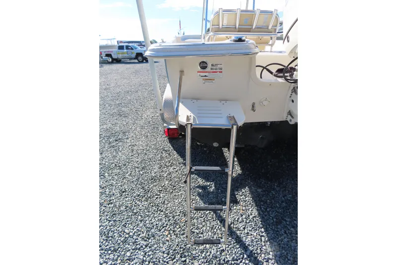 Slide: The Image of 2017 Carolina Skiff 238 DLV boat with rear ladder on gravel surface. - 5