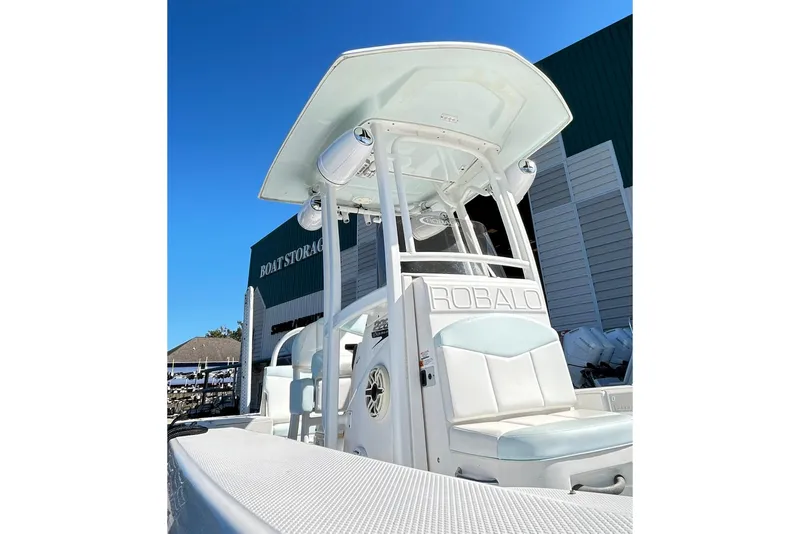Slide: The Image of 2019 Robalo 226 Cayman boat with T-top, docked near storage facility. - 10