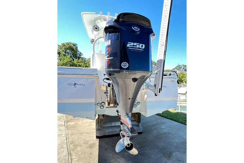 Slide: The Image of 2019 Robalo 226 Cayman with Yamaha 250 outboard motor, parked on concrete. - 16