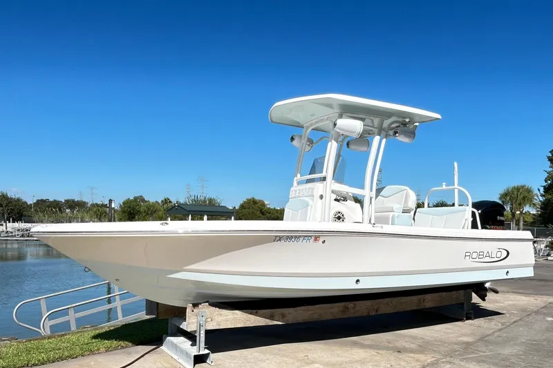 Slide: The Image of 2019 Robalo 226 Cayman boat on display by the water under clear blue sky. - 3