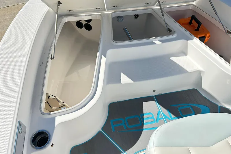 Slide: The Image of 2019 Robalo 226 Cayman boat interior with open storage compartments and branded flooring. - 34