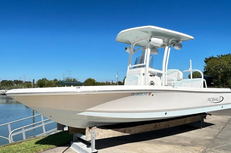Slide: The Image of 2019 Robalo 226 Cayman boat on display by the water under clear blue sky. - 4