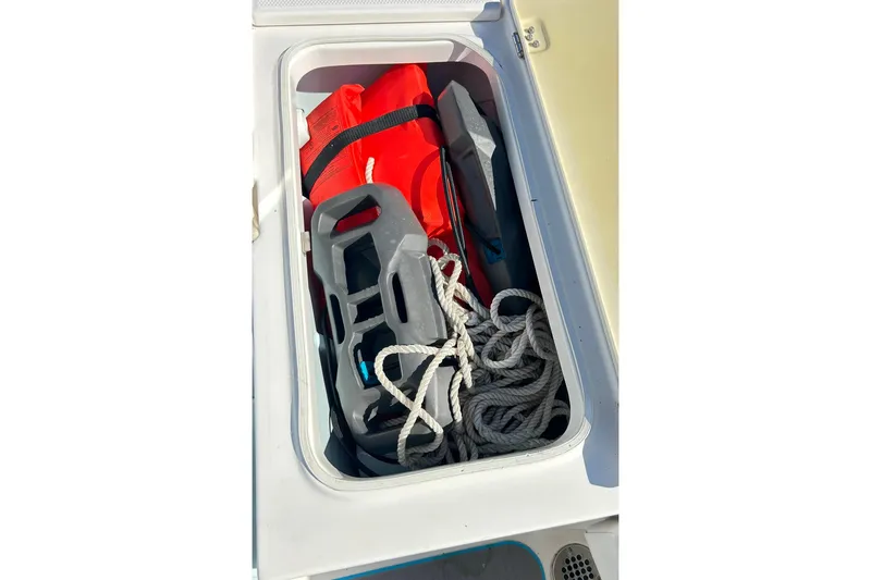 Slide: The Image of Storage compartment of 2019 Robalo 226 Cayman boat with life jacket and rope. - 43