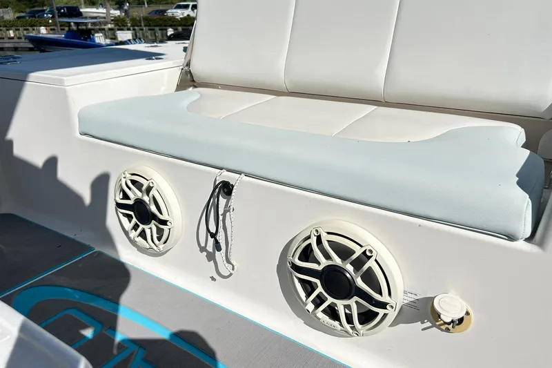Slide: The Image of 2019 Robalo 226 Cayman boat interior with cushioned seating and built-in speakers. - 45