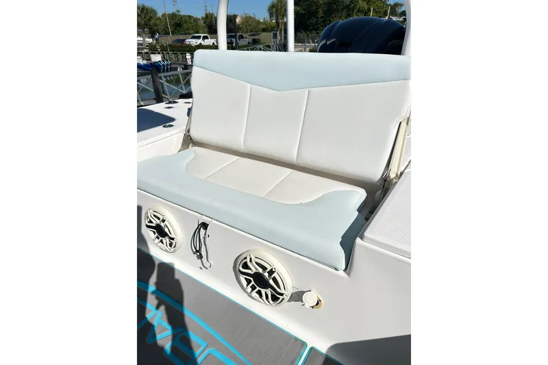 Slide: The Image of 2019 Robalo 226 Cayman boat seat with speakers, docked outdoors. - 46