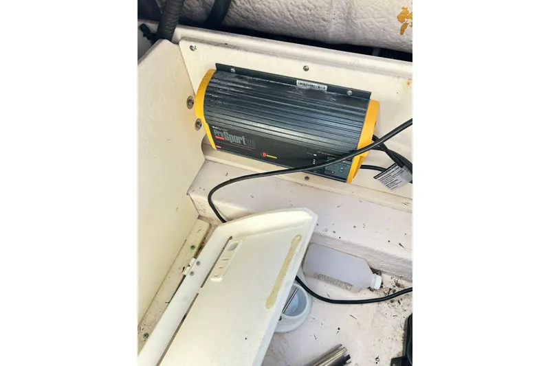 Slide: The Image of Battery charger in a 2019 Robalo 226 Cayman boat compartment. - 52