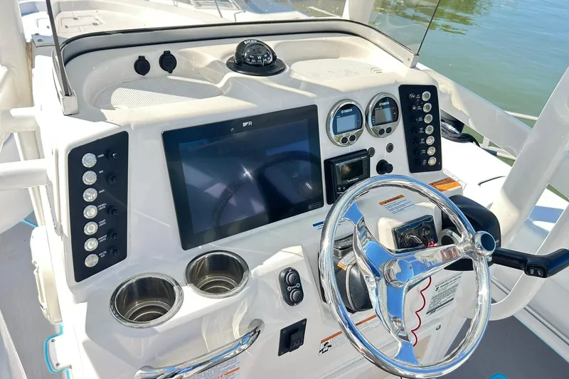 Slide: The Image of 2019 Robalo 226 Cayman boat dashboard with steering wheel and navigation controls. - 54