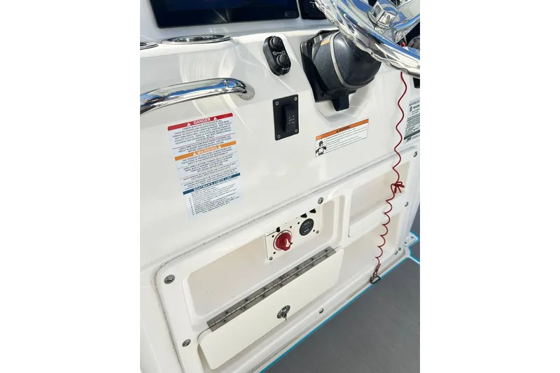 Slide: The Image of 2019 Robalo 226 Cayman boat dashboard with steering wheel and safety instructions. - 56