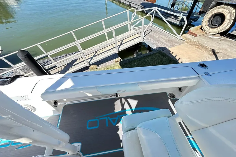 Slide: The Image of 2019 Robalo 226 Cayman boat interior with white seating and dock view. - 62