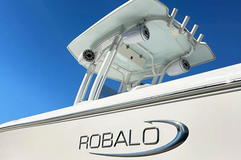 Slide: The Image of 2019 Robalo 226 Cayman boat with T-top and speakers against clear blue sky. - 8