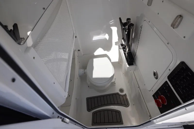 Slide: The Image of Interior of 2026 Sea Hunt Ultra 275 SE boat, featuring a compact marine toilet. - 16
