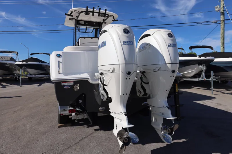 Slide: The Image of 2026 Sea Hunt Ultra 275 SE boat with dual Yamaha 200 engines, parked outdoors. - 24