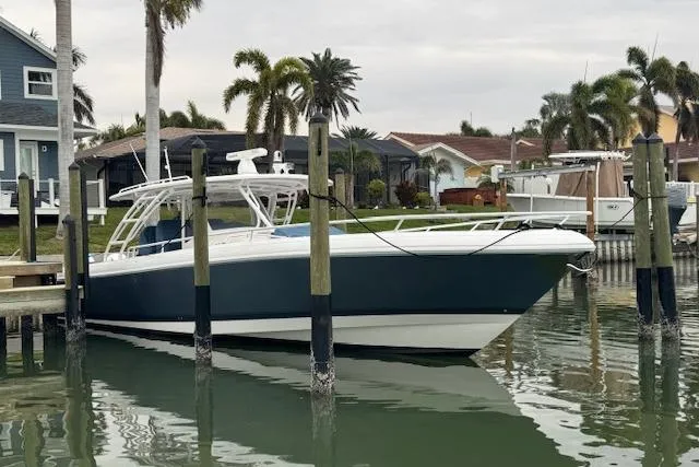 The Image of 2016 Intrepid 475 Panacea docked near waterfront homes with palm trees. - 0