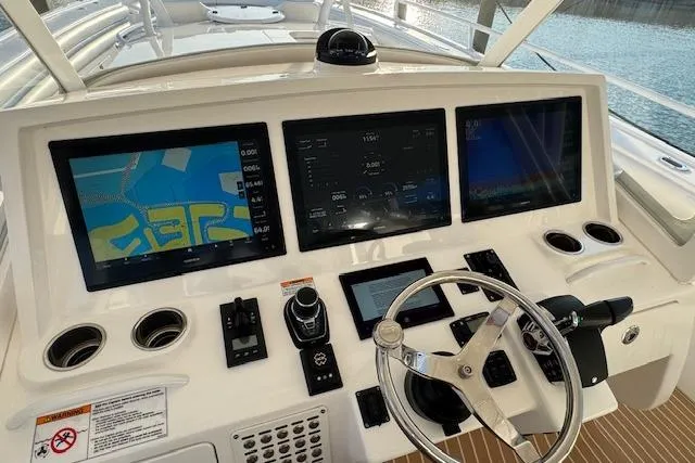 Slide: The Image of Control panel of a 2016 Intrepid 475 Panacea boat with navigation screens and steering wheel. - 12