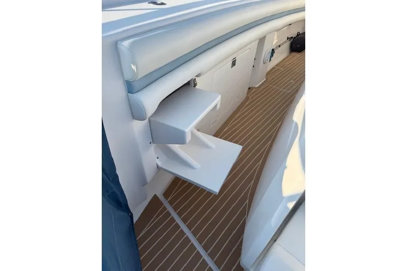 Slide: The Image of 2016 Intrepid 475 Panacea boat interior with foldable steps and cushioned seating. - 18