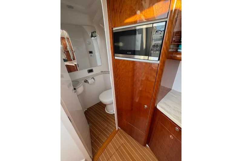 Slide: The Image of Interior of 2016 Intrepid 475 Panacea featuring a compact bathroom and microwave. - 23