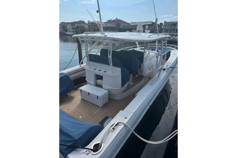 Slide: The Image of 2016 Intrepid 475 Panacea boat docked, featuring spacious deck and covered seating area. - 4