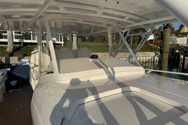 Slide: The Image of 2016 Intrepid 475 Panacea boat docked, featuring sleek design and spacious seating area. - 6