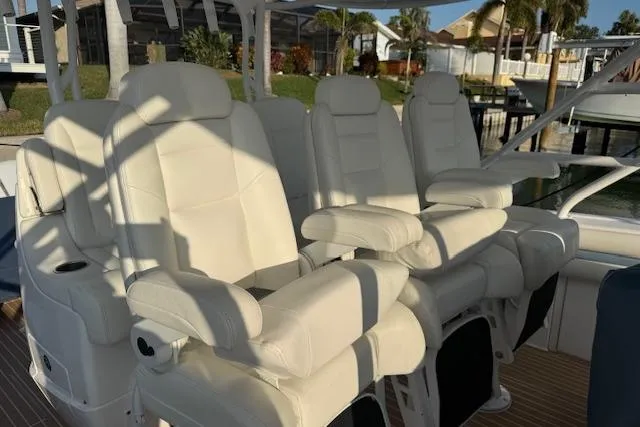 Slide: The Image of Luxurious white seating on a 2016 Intrepid 475 Panacea boat, docked near waterfront homes. - 9