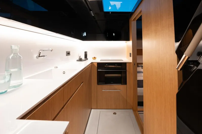 Slide: The Image of Modern kitchen interior of 2026 De Antonio Yachts D60, featuring sleek wood cabinetry and minimalist design. - 26