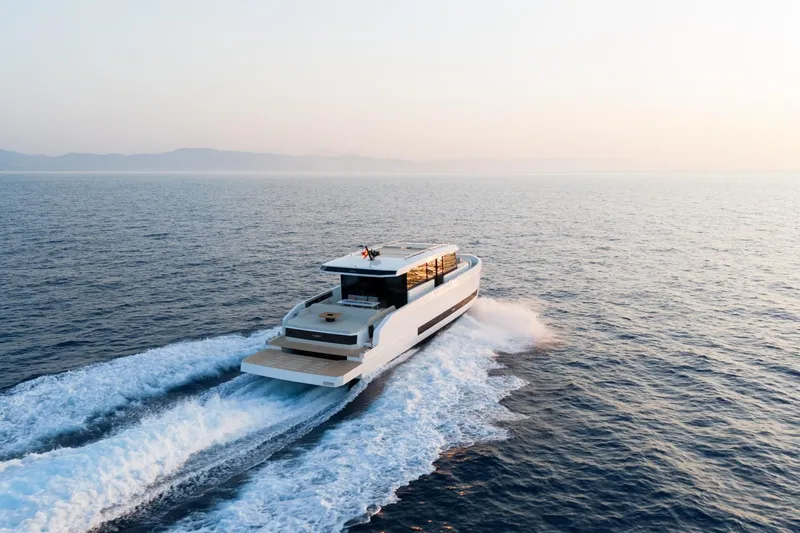 Slide: The Image of 2026 De Antonio Yachts D60 cruising on open sea at sunset. - 9