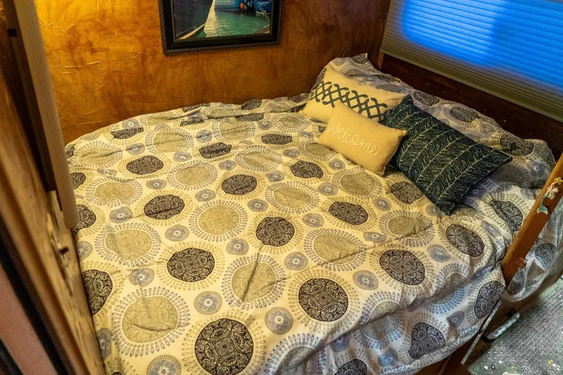 Slide: The Image of Cozy bedroom in 1989 Seabreeze houseboat with patterned bedding and decorative pillows. - 20