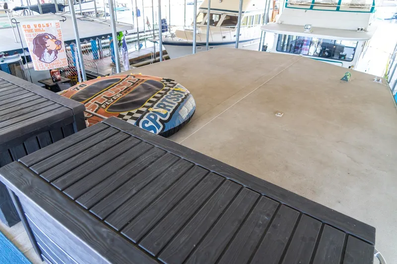 Slide: The Image of 1989 Seabreeze 53 x 14 houseboat deck with inflatable water toys and docked boats. - 35