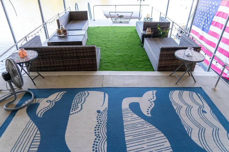 Slide: The Image of 1989 Seabreeze houseboat deck with wicker furniture, green turf, and American flag. - 36