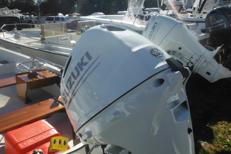 Slide: The Image of 1973 Boston Whaler 13 Sport Side with Suzuki outboard motor in a boatyard. - 5