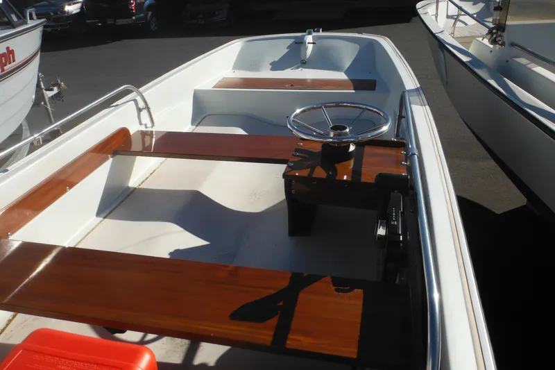 Slide: The Image of 1973 Boston Whaler 13 Sport Side boat interior with wooden seats and steering wheel. - 8