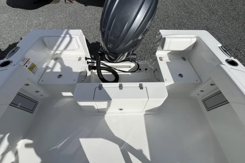Slide: The Image of 2026 Parker 210 Coastal boat interior with motor, storage compartments, and seating. - 2