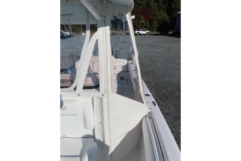 Slide: The Image of 2018 Sea Hunt Ultra 234 boat interior with protective cover, parked outdoors. - 14