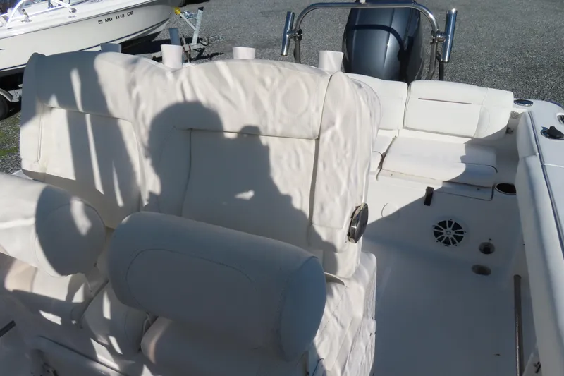 Slide: The Image of 2018 Sea Hunt Ultra 234 boat interior with white seating and engine view. - 17