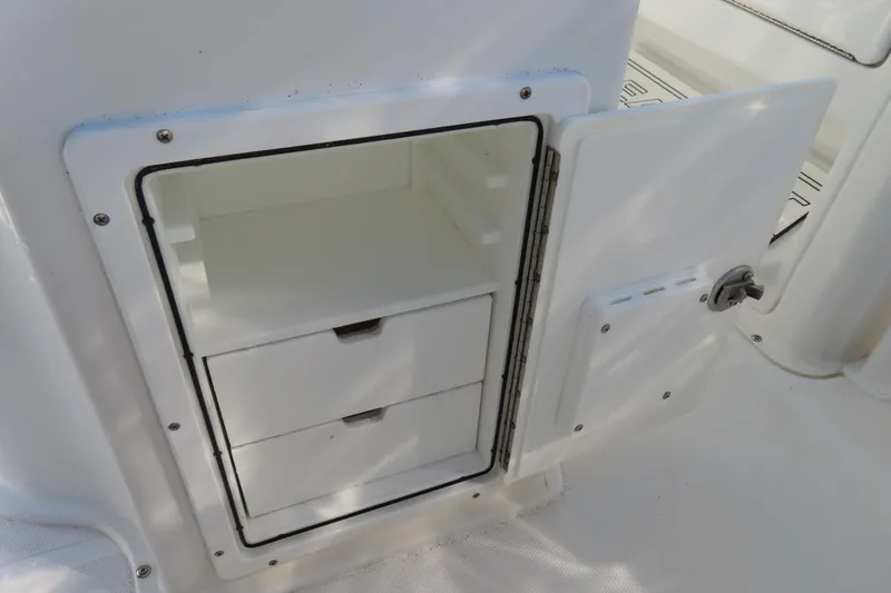 Slide: The Image of Open storage compartment with drawers on a 2018 Sea Hunt Ultra 234 boat. - 27