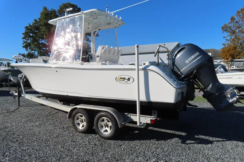Slide: The Image of 2018 Sea Hunt Ultra 234 boat on trailer with Yamaha outboard motor, parked outdoors. - 3