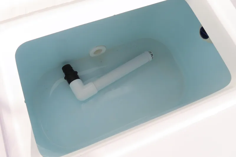 Slide: The Image of Livewell tank in 2018 Sea Hunt Ultra 234 boat, featuring a white pipe and blue interior. - 31