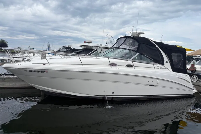 The Image of 2006 Sea Ray 300 Sundancer boat docked at marina under cloudy sky. - 0