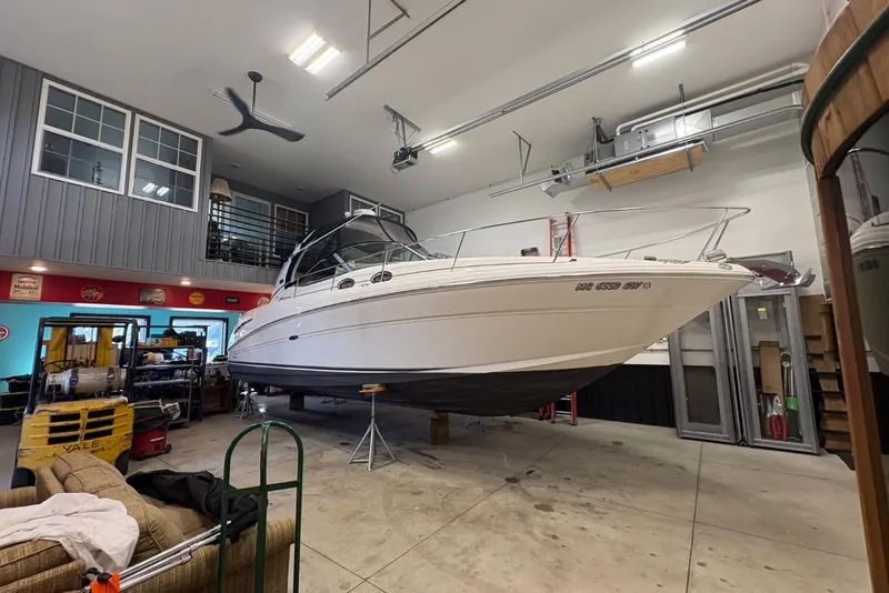 Slide: The Image of 2006 Sea Ray 300 Sundancer boat in a spacious indoor garage setting. - 1