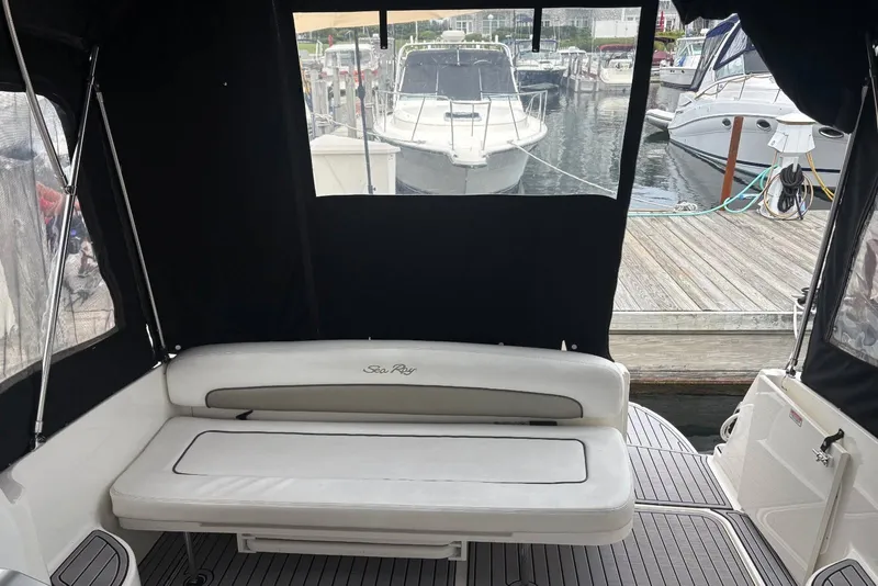 Slide: The Image of Interior view of a 2006 Sea Ray 300 Sundancer boat with docked vessels in the background. - 12