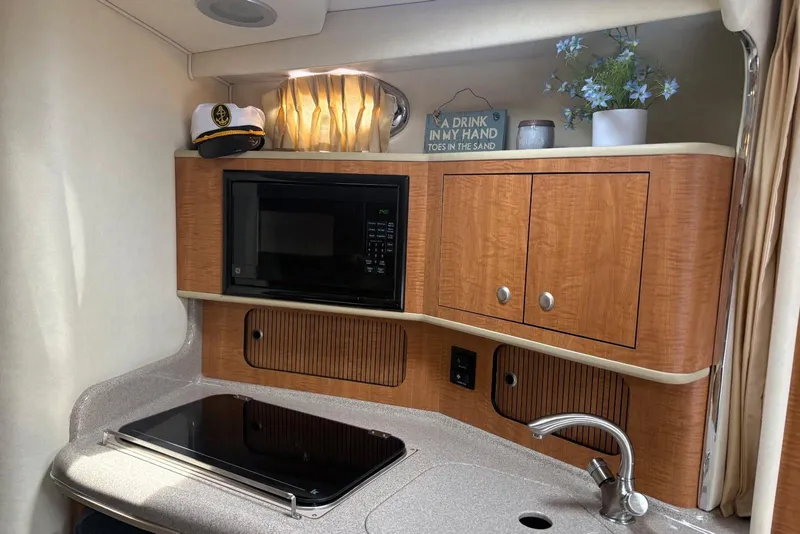 Slide: The Image of 2006 Sea Ray 300 Sundancer cabin with kitchenette, microwave, and decor. - 18