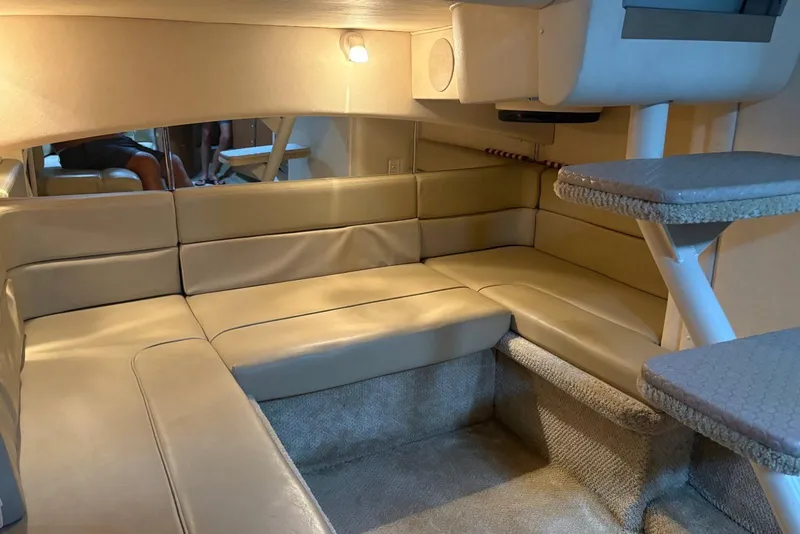 Slide: The Image of Interior of 2006 Sea Ray 300 Sundancer with beige leather seating and carpeted flooring. - 19