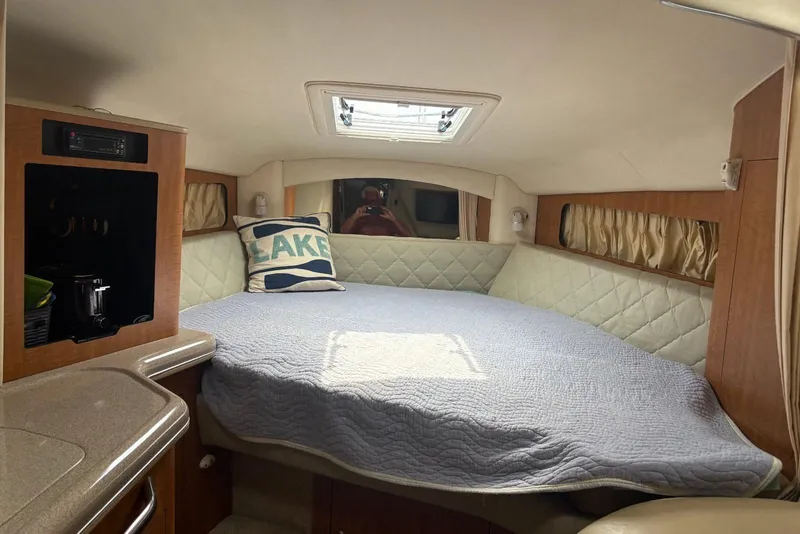 Slide: The Image of 2006 Sea Ray 300 Sundancer cabin interior with bed, pillow, and natural light. - 20