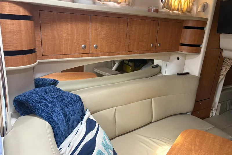 Slide: The Image of Interior of 2006 Sea Ray 300 Sundancer with beige seating and wooden cabinetry. - 21