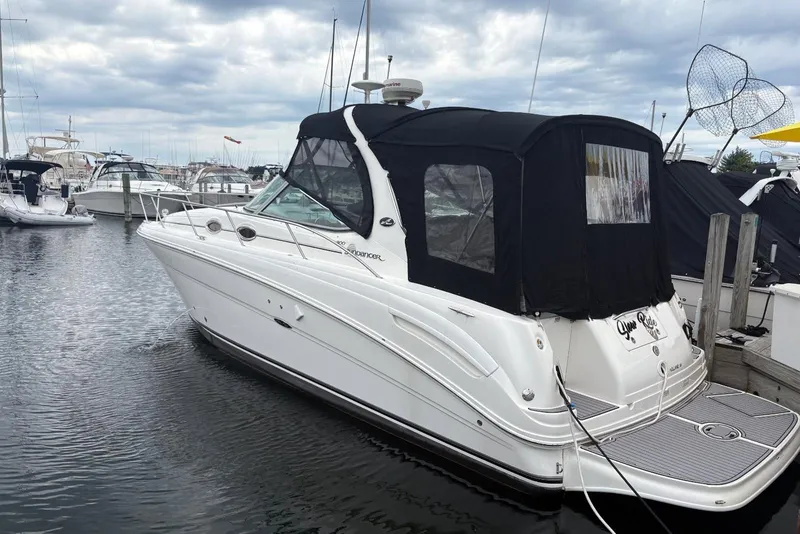 Slide: The Image of 2006 Sea Ray 300 Sundancer boat docked in a marina under cloudy skies. - 4