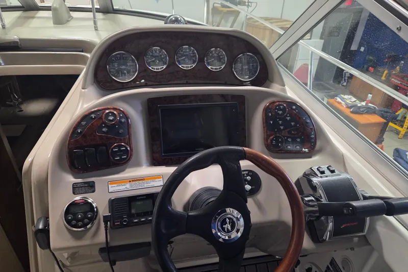 Slide: The Image of Control panel of a 2006 Sea Ray 300 Sundancer boat with gauges and steering wheel. - 8