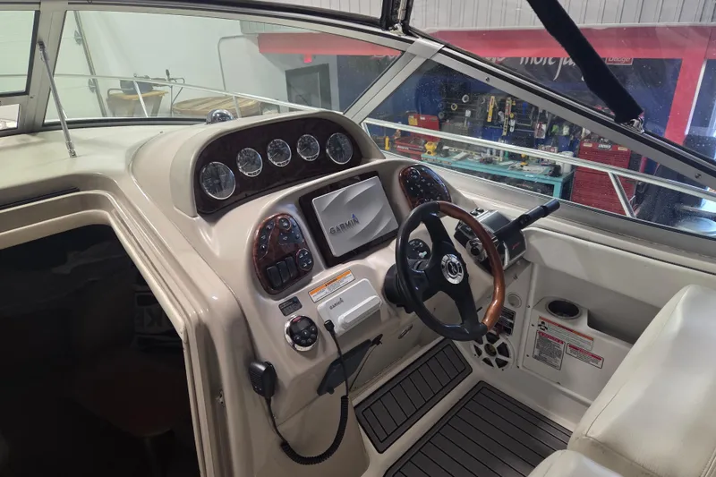 Slide: The Image of 2006 Sea Ray 300 Sundancer helm with Garmin navigation, gauges, and steering wheel. - 9
